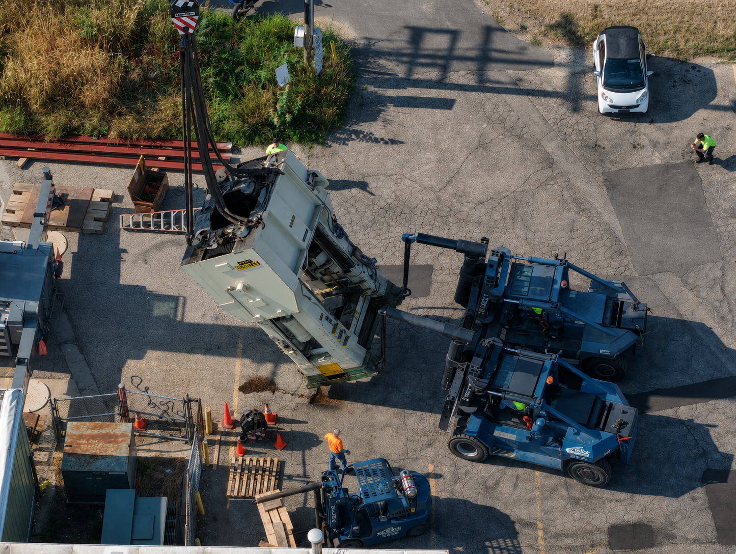 Aerial view of a Gelock crew using a crane and forklifts to rig an industrial press
